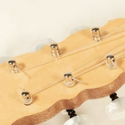 Cabeça de guitarra elétrica em madeira clara com cravelhas e cordas