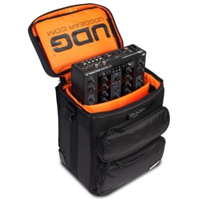 Mochila preta com interior laranja e mesa de mistura preta dentro.