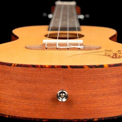 Ukulele de madeira com tampo claro e corpo escuro, cordas brancas e detalhe decorativo