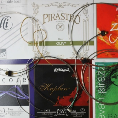 Embalagens de cordas para contrabaixo de várias marcas com cordas visíveis