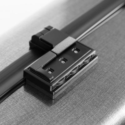 Fecho de combinação preto numa mala cinzenta texturizada