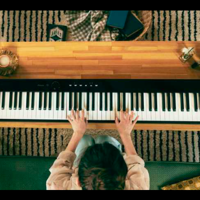 Piano digital preto numa bancada de madeira com tapete geométrico por baixo