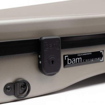 Estojo rígido bege com fecho preto e etiqueta 'POLYCARBONATE bam l'original'