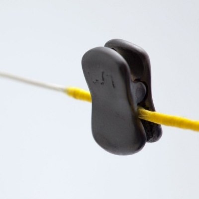 Clipe preto de plástico prendendo um cordão amarelo