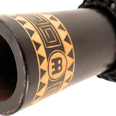 Close-up do topo de um djembe preto com padrão amarelo geométrico e cordas de afinação pretas.