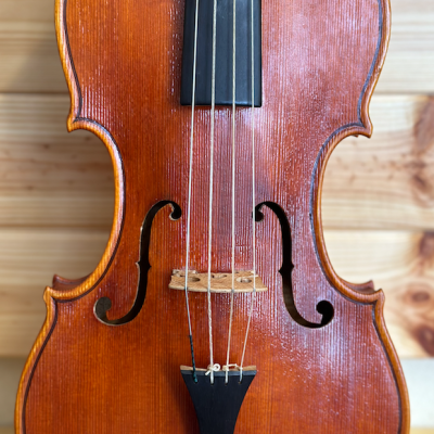 Violino de madeira laranja com cordas e cravelhas pretas