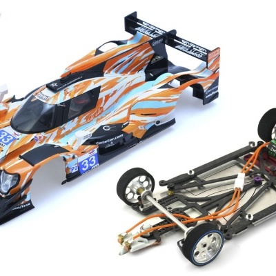 Miniatura de carro de corrida LMP Oreca 07 com carroçaria com padrões laranja, azul e branco ao lado de chassis completo para slot car