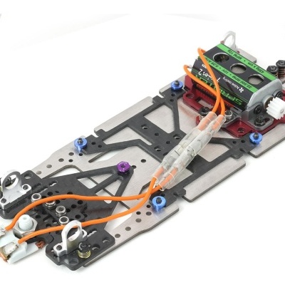 Chassi de slot car metálico preto com motor e fios laranja