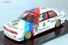 Modelo de carro de corrida BMW em escala branco com detalhes coloridos e logos de patrocinadores