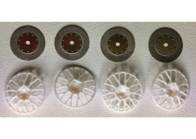 Tampas de jantes de carro brancas com discos metálicos circulares, em superfície branca