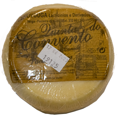 Queijo redondo embalado em plástico com rótulo castanho com texto e data de validade