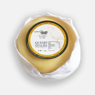 Queijo de ovelha redondo com etiqueta central preta, branca e dourada sobre fundo branco