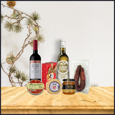 Produtos gastronómicos portugueses variados sobre mesa de madeira com ramo de pinheiro ao fundo