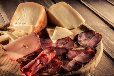 Queijos e enchidos variados num tabuleiro de madeira