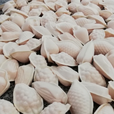 Peças decorativas em tons de branco e rosa claro com formas de conchas e frutas