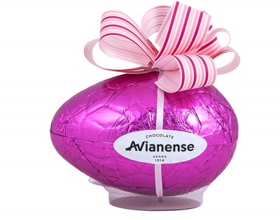 Ovo de chocolate embrulhado em papel rosa metálico com laço decorativo e rótulo oval branco