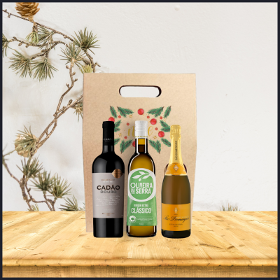 Três garrafas em frente a embalagem decorativa com ramo de pinheiro ao fundo
