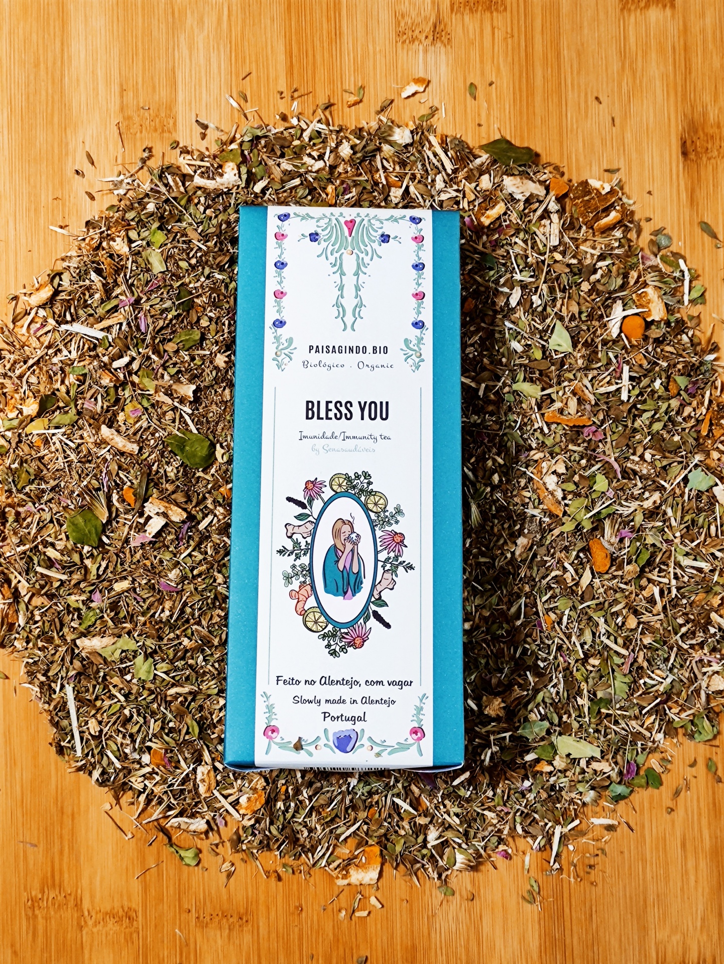 Pack 3 Tisanas "STRONGER" 💪 Embalagem de chá Bless You com design floral rodeada por ervas secas sobre madeira