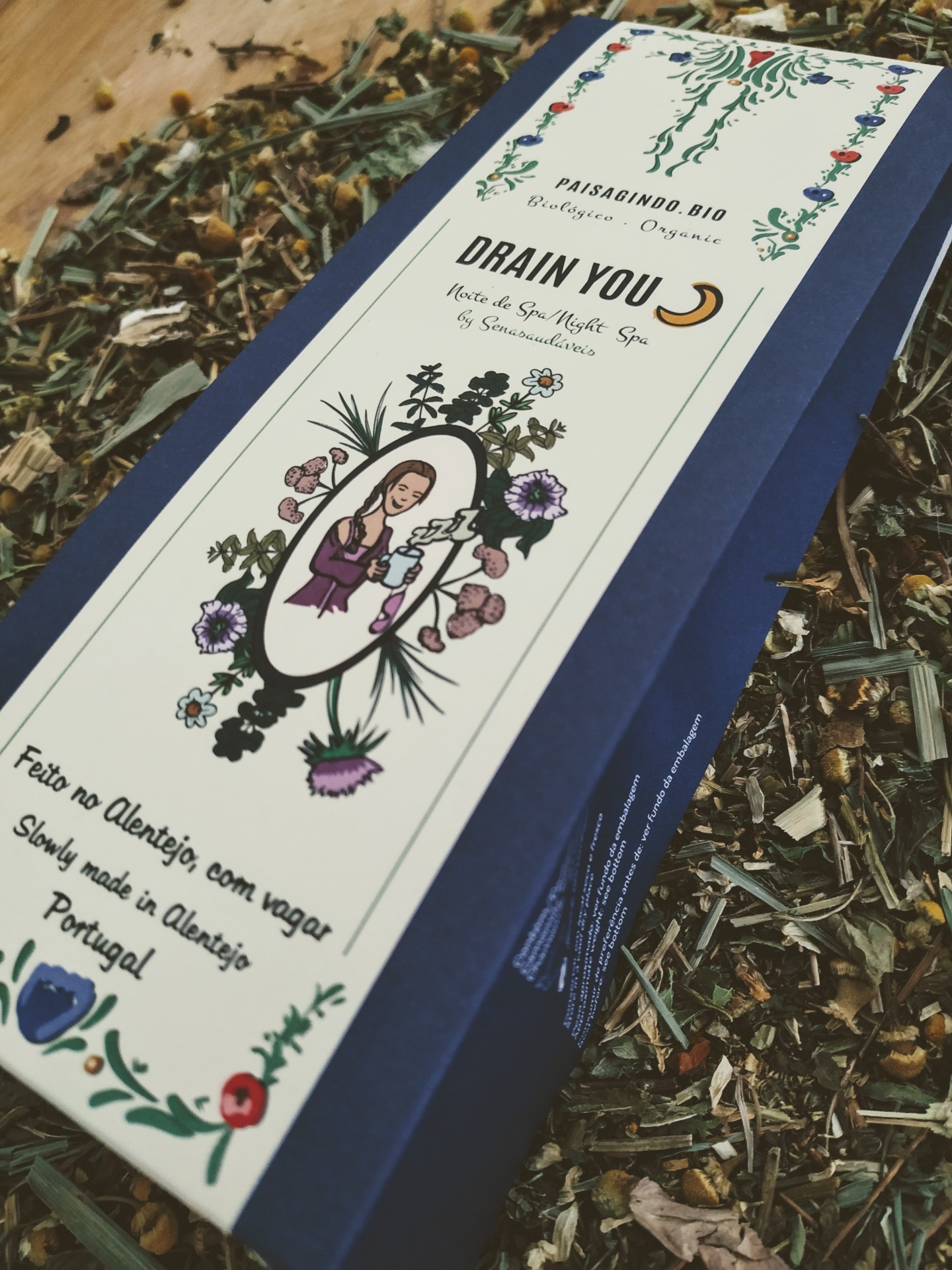 DRAIN YOU Noite de Spa🌙 by "Senasaudáveis" Caixa azul com rótulo branco decorado com plantas, texto em português e inglês, em cima de ervas secas