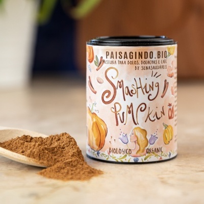 Lata cilíndrica de mistura em pó para bolos com design colorido e colher de madeira com pó castanho