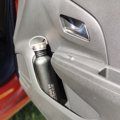 Garrafa metálica cinza escuro na porta de carro cinza