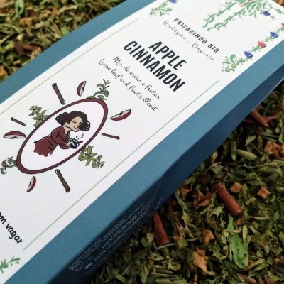 Embala orgânica de chá Apple Cinnamon sobre folhas secas e pauzinhos de canela