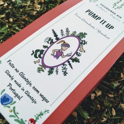 Embalagem retangular cor-de-rosa com etiquetas brancas decoradas e texto, em fundo de folhas secas