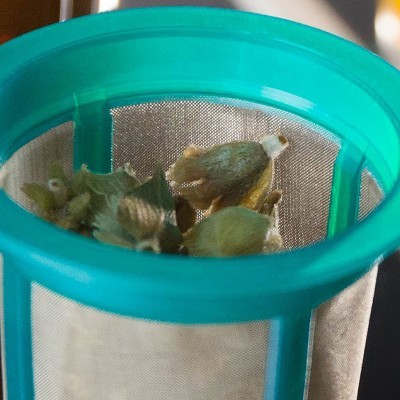 Filtro de chá azul-turquesa com flores secas dentro