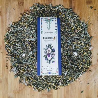 Pacote de ervas Drain You sobre ervas secas em superfície de madeira