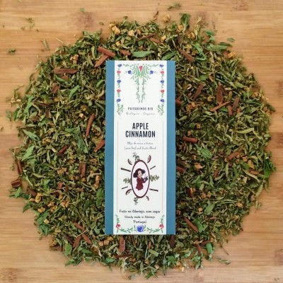 Pacote de chá Apple Cinnamon rodeado por folhas secas e canela