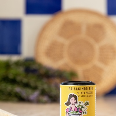 Frasco de ervas aromáticas biológicas amarelo com colher de madeira e fundo de azulejos azuis e brancos