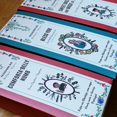 Caixas coloridas com etiquetas decorativas e textos em inglês e português