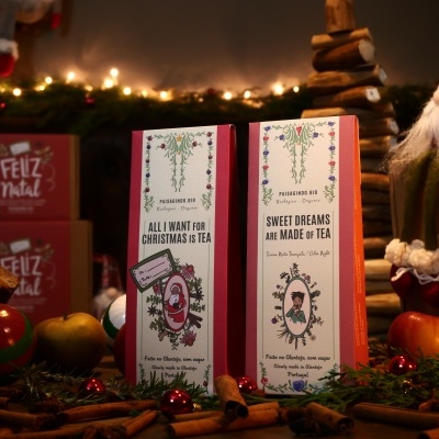 Caixas de chá com design floral e texto em inglês, em ambiente decorado para o Natal.