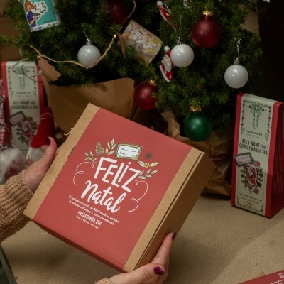 Caixa de presente de Natal com decoração e árvores de Natal pequenas ao fundo