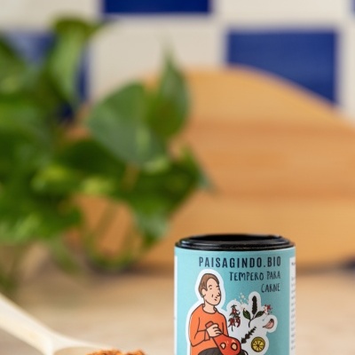 Embalagem de tempero para carne PAISAGINDO.BIO e colher com tempero sobre bancada