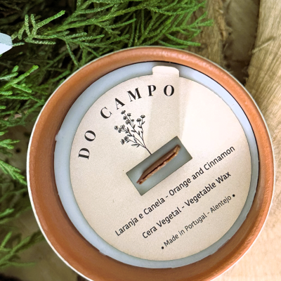 Vela aromática em recipiente de barro com rótulo redondo e pavio de madeira