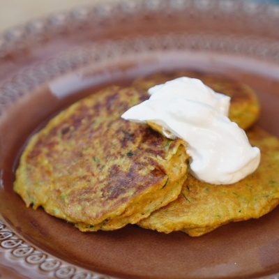 Bolinhos dourados com creme branco num prato castanho decorado