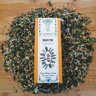 Pacote de chá seco da marca Passionde.Bio com mistura de ervas coloridas em superfície de madeira