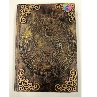 Caderno de capa de couro castanho com gravação circular e arabescos dourados nos cantos