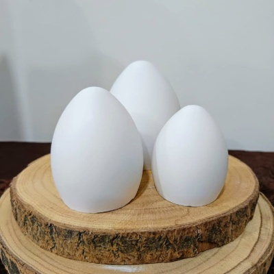 Três ovos brancos sobre bases de madeira redondas.