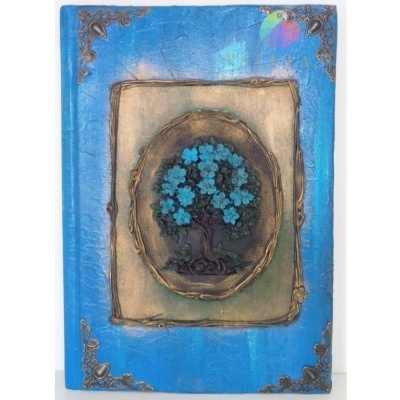 Livro azul com árvore em relevo e detalhes dourados na capa