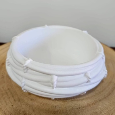 Recipiente branco redondo texturizado sobre madeira