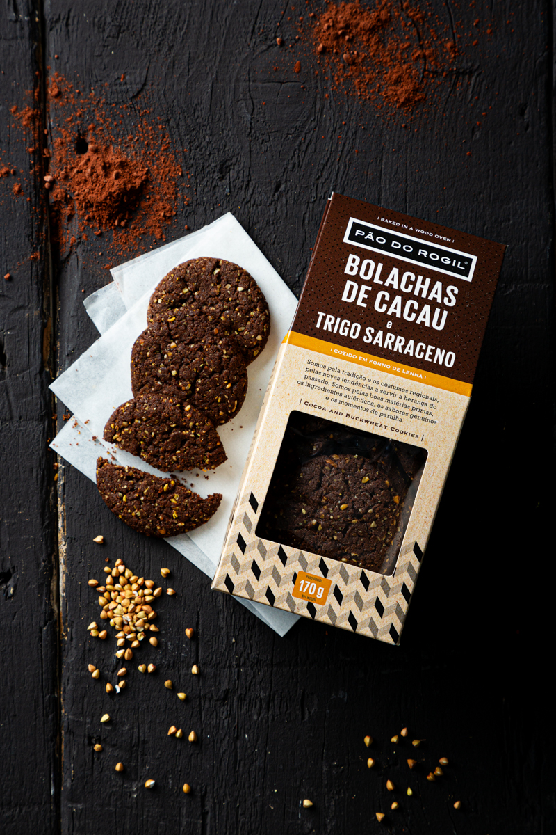 Pacote e bolachas de cacau e trigo sarraceno Pão do Rogil em fundo preto