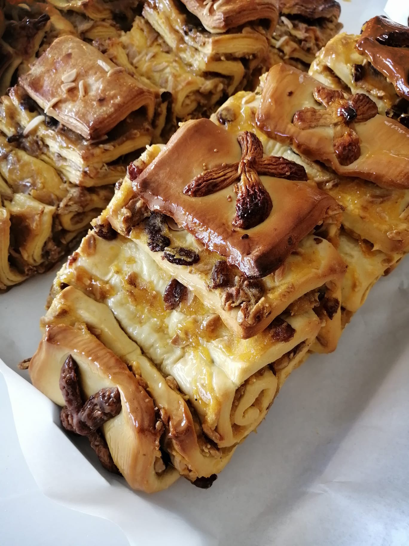 Doces folhados com passas e frutos secos sobre papel branco
