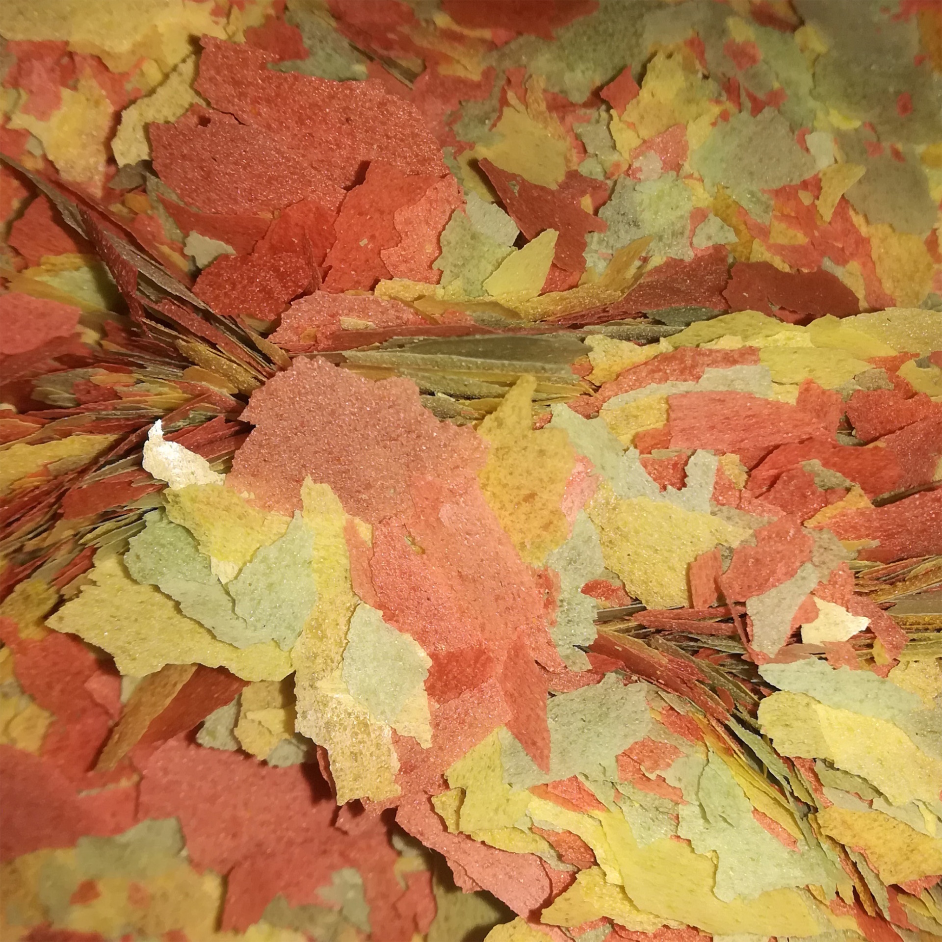 Flocos Goldfish Flocos coloridos de ração para peixes em tons de vermelho, amarelo, verde e laranja