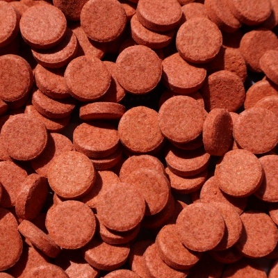 Pastilhas redondas castanhas-avermelhadas com textura granulada