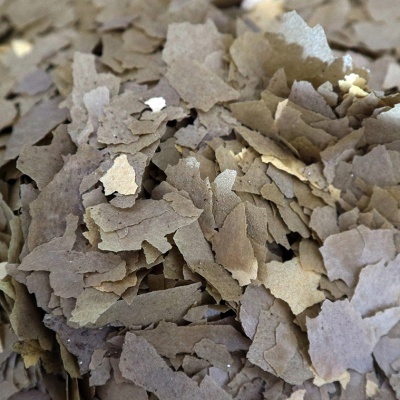 Lâminas finas e irregulares marrons com textura áspera sobre superfície indefinida