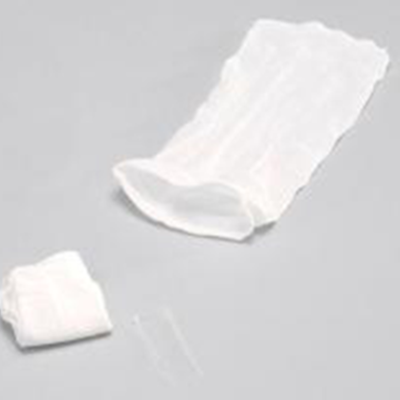 Estojo branco transparente, tubo de plástico e tecido branco dobrado sobre superfície cinza.