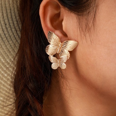 Brincos dourados de borboleta em orelha