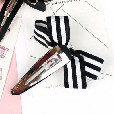 Prendedor de cabelo metálico com laço preto e branco